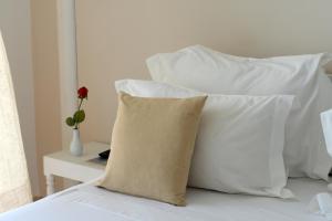 a pile of white pillows sitting on a bed at Dar Corniche La Marsa (Adults Only) in La Marsa