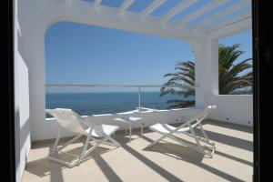 a balcony with a table and chairs and the ocean at Dar Corniche La Marsa (Adults Only) in La Marsa