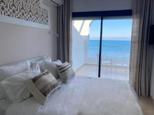 a bedroom with a bed with a view of the ocean at Dar Corniche La Marsa (Adults Only) in La Marsa