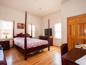 a bedroom with a four poster bed and a desk at The Windsor Inn in Cambridge