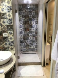 a bathroom with a shower with blue and white tiles at Dar Corniche La Marsa (Adults Only) in La Marsa