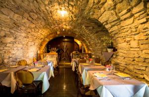 a dining room with tables in a stone wall at Hotel Remàt in Garda