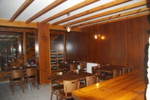 a dining room with wooden tables and chairs at Hotel Rustico Casa Do Vento in Bayo