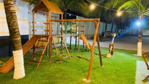 a playground with a ladder and a swing at Pousada Italia Beach in Aquiraz