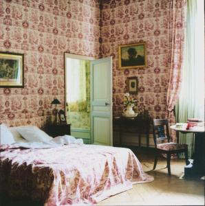 een slaapkamer met een bed met roze behang bij Le Château de BRESSEY & son Orangerie in Bressey-sur-Tille