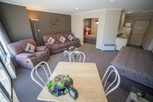 sala de estar con sofá y mesa en Lakefront Lodge en Te Anau