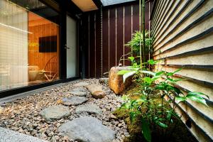 a patio with rocks and plants next to a building at Kikokutei Bekkan in Kyoto