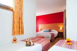 une chambre d'hôtel avec deux lits avec des ours en peluche assis sur eux dans l'établissement The Originals City, Hôtel Mâcon Sud, à Chaintré