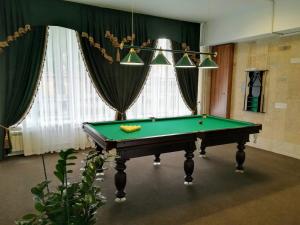 een pooltafel in een kamer met gordijnen en een plafond bij Hotel Kuzbass in Kemerovo