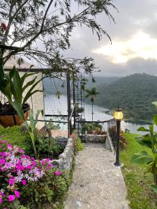 a pathway with flowers and a view of a lake at Casa maar -Tented Camp in Río Cuarto