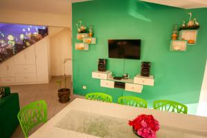 a dining room with a table and a green wall at Matices del Mar en Canoas in Canoas De Punta Sal