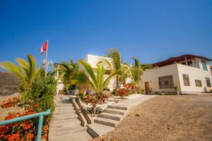 a house with stairs and palm trees in front of it at Matices del Mar en Canoas in Canoas De Punta Sal