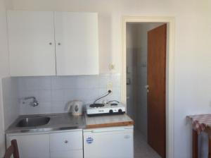 a kitchen with white cabinets and a sink and a counter at Rania Apartments in Antiparos Town