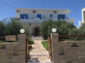 a gate to a house with a building in the background at Rania Apartments in Antiparos Town