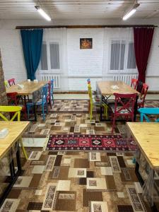 un comedor con mesas, sillas y una alfombra en Kolsay Aisha, en Saty