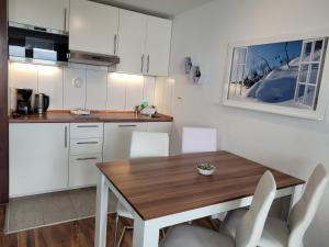 a kitchen with a wooden table and white cabinets at Ferienwohnung Bergpanorama mit Pool in Sankt Englmar