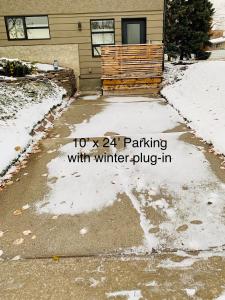 a driveway with snow in front of a house at Studio on Capri in Calgary