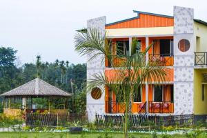 una casa con techo naranja y cenador en Jungle Bell Resort, en Lataguri