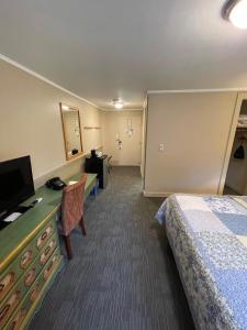 a hotel room with a bed and a television at Northern Lights Lodge in Stowe