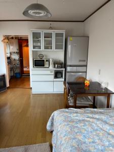 eine Küche mit einem Kühlschrank und einem Tisch im Zimmer in der Unterkunft City Otaru in Otaru