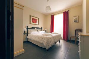 a bedroom with a bed and a window with red curtains at Agriturismo PIAN DEL GRANO Azienda agricola in Grotte di Castro
