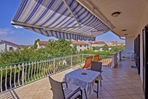een patio met een tafel en stoelen en een parasol bij Anka in Medulin * Istrien in Medulin