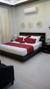 a bedroom with a large bed with red pillows at Shahi Palace Hotel in Chīchāwatni