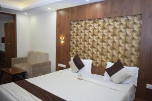 a hotel room with a bed and a chair at Hotel Apple Valley in Kodaikānāl