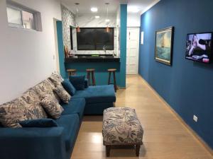 a living room with a blue couch and a table at Apartamento beira mar - Praia de Boraceia in Bertioga