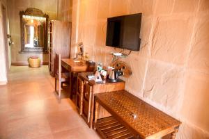 a room with a table and a television on a wall at Puratan Qila in Sawāi Mādhopur