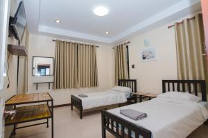 Habitación hospitalaria con 2 camas y mesa en Riverview Loft house, en Uthai Thani