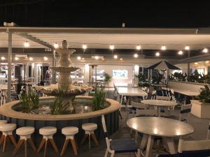 um restaurante com uma fonte e mesas e cadeiras em Agapi on Cambridge em Umina