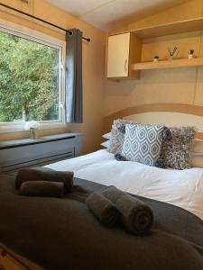 a bedroom with a bed with towels on it at Percy Wood Lodge with Hot Tub near Alnwick in Swarland