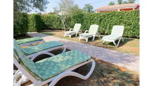 a group of lawn chairs sitting in a yard at Holiday Home Tina in Savudrija
