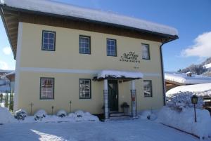 a building with snow on the ground in front of it at Appartment Martin in Westendorf