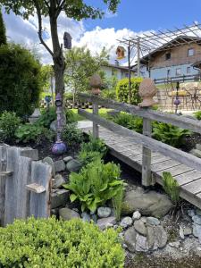 un jardín con un puente de madera y algunas plantas en Appartment Martin, en Westendorf