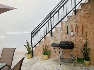 a grill sitting under a staircase with plants at AKBAL Playa - Beach Zone in Playa del Carmen