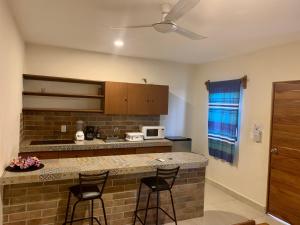 eine Küche mit Theke und zwei Barhockern in der Unterkunft AKBAL Playa - Beach Zone in Playa del Carmen