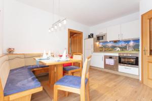 cocina y comedor con mesa y sillas en Appartements Wagnerhaus en Maria Alm am Steinernen Meer