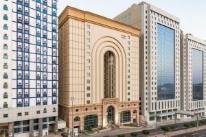 een groot gebouw in een stad met hoge gebouwen bij Makarem Umm Al Qura Hotel in Mekka