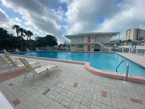 ベニスにあるBeachfront Venice Casa de Villaの大きなスイミングプール(椅子2脚付)と建物