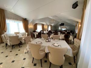Sokolniki Hotel في خاباروفسكي: غرفة طعام مع طاولات وكراسي في مطعم