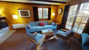 a living room with a blue couch and chairs at Numaga in Blatten bei Naters