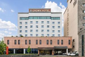 a large white building with a brown hotel at Crown Hotel Changwon in Changwon