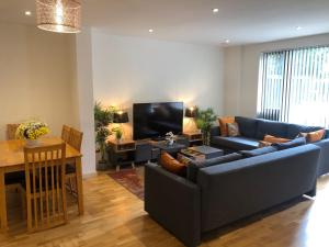un soggiorno con divano e TV di FW Haute Apartments at Queensbury, Ground Floor 2 Bedrooms and 2 Bathrooms with King or Twin beds with Front Porch and FREE WIFI and FREE PARKING a Wealdstone