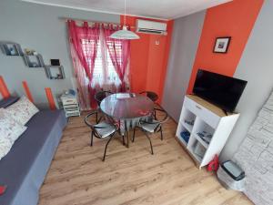 a small room with a glass table and a bed at Apartman Sunce in Murter