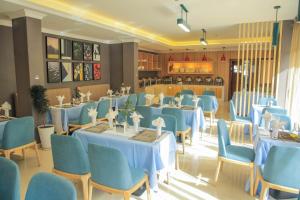 Debre ZeyitIvy Hotel, Bishoftu的一间配备有蓝色桌椅的用餐室