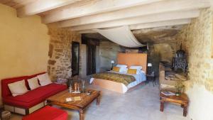 a bedroom with a large bed and a red couch at Le Clos Saint Saourde in Beaumes-de-Venise