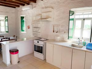 a white kitchen with a sink and a stove at Anezina Village in Drios