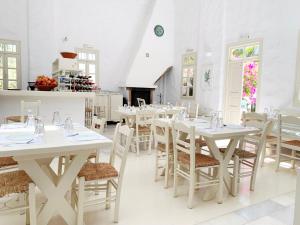 a dining room with white tables and chairs at Anezina Village in Drios +67 photos